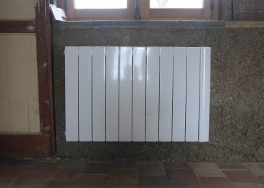 Ici un radiateur est fixé sur une pièce de bois posé avant la